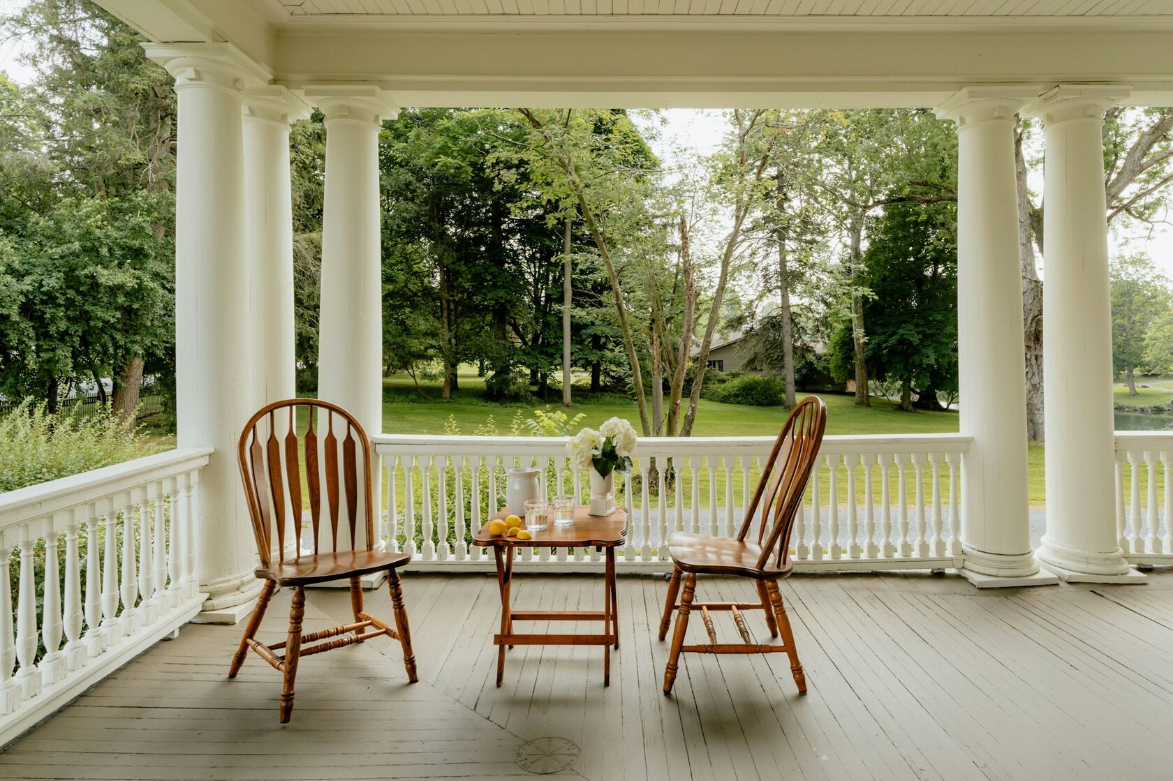A cabin verandah with outdoor seating looking out to the trees